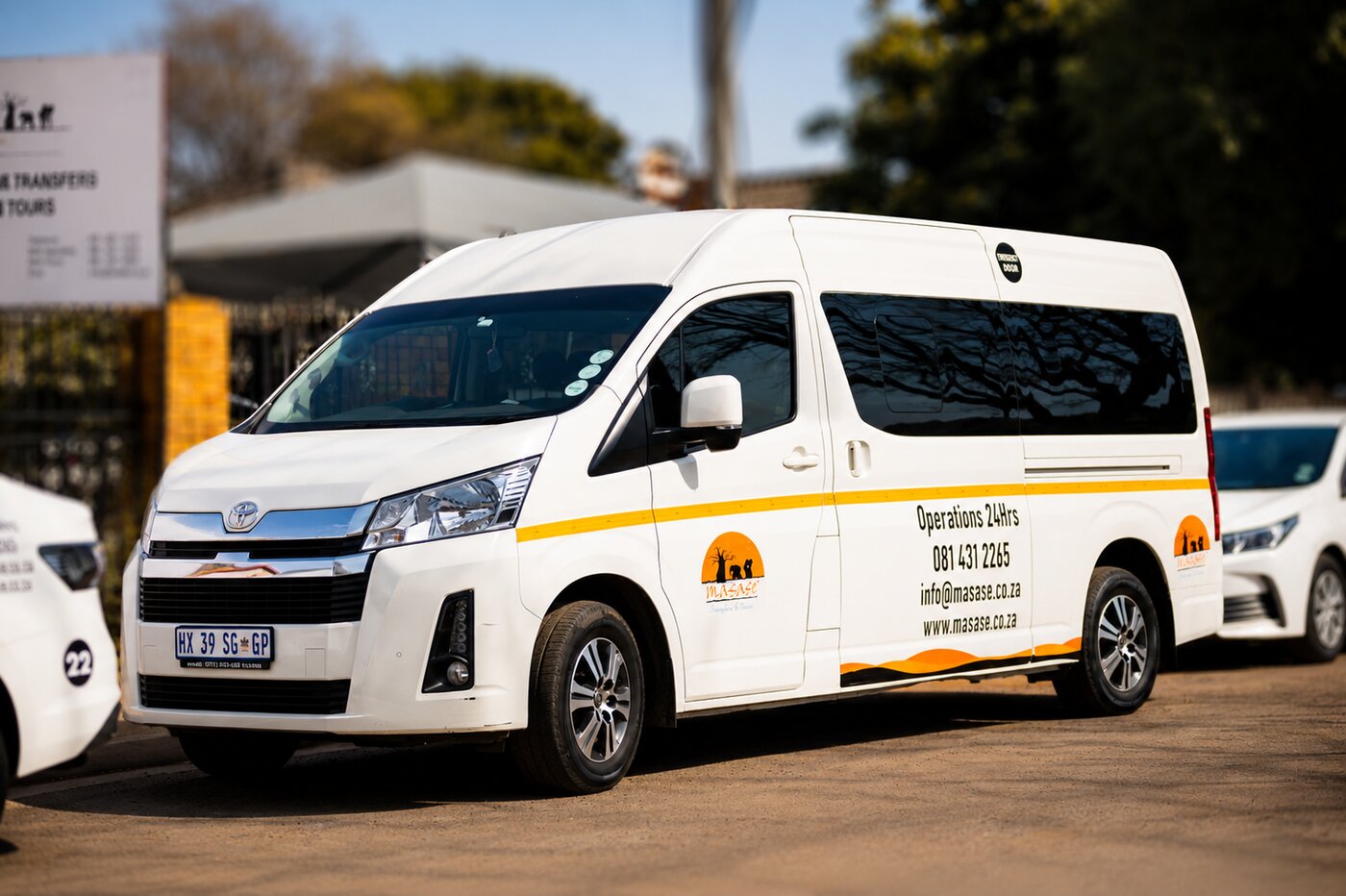 A Masase mini bus and sedan parked together